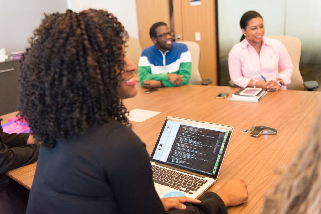 A diverse group of professionals collaborating in a modern office environment with laptops and technology.
